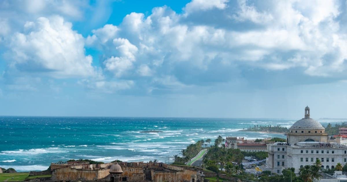 Captivating view of the historic San Juan coastline with El Morro fortress and ocean waves.