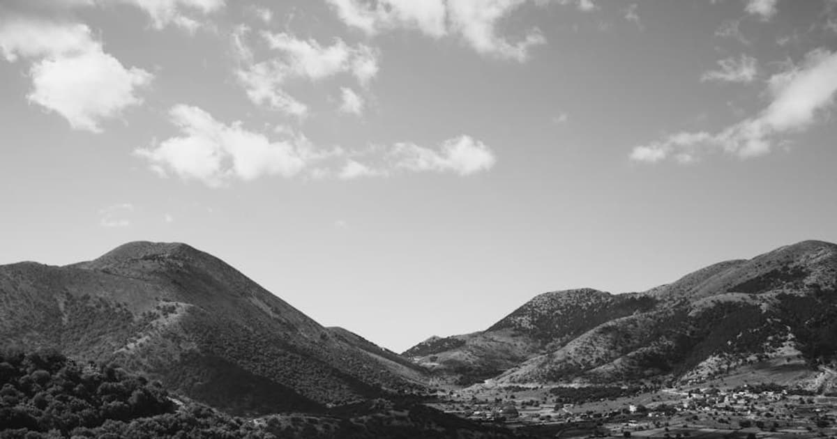 A stunning black and white aerial view capturing scenic countryside hills and rural landscape.