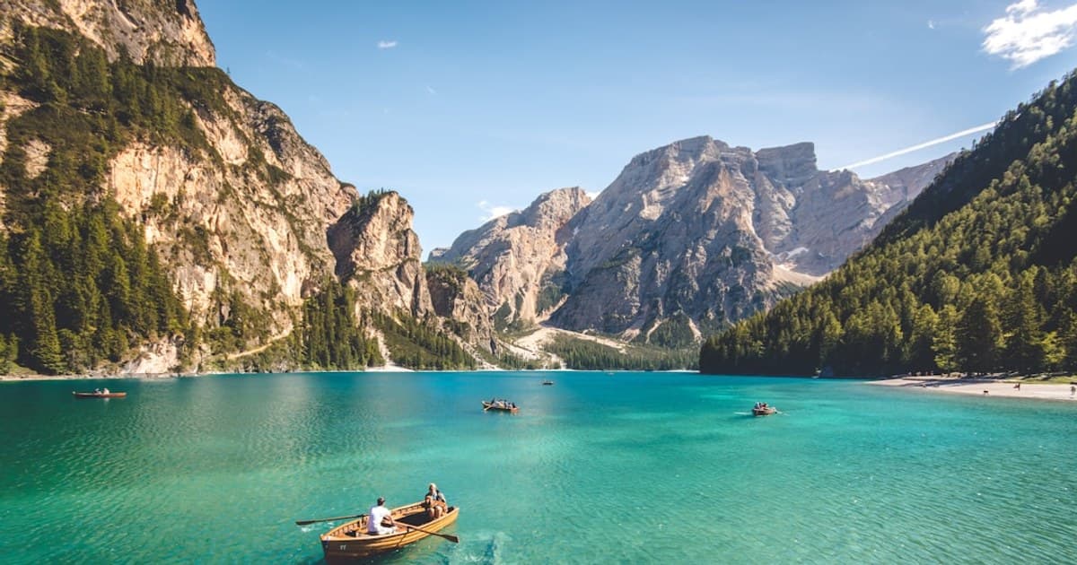 three brown wooden boat on blue lake water taken at daytime
