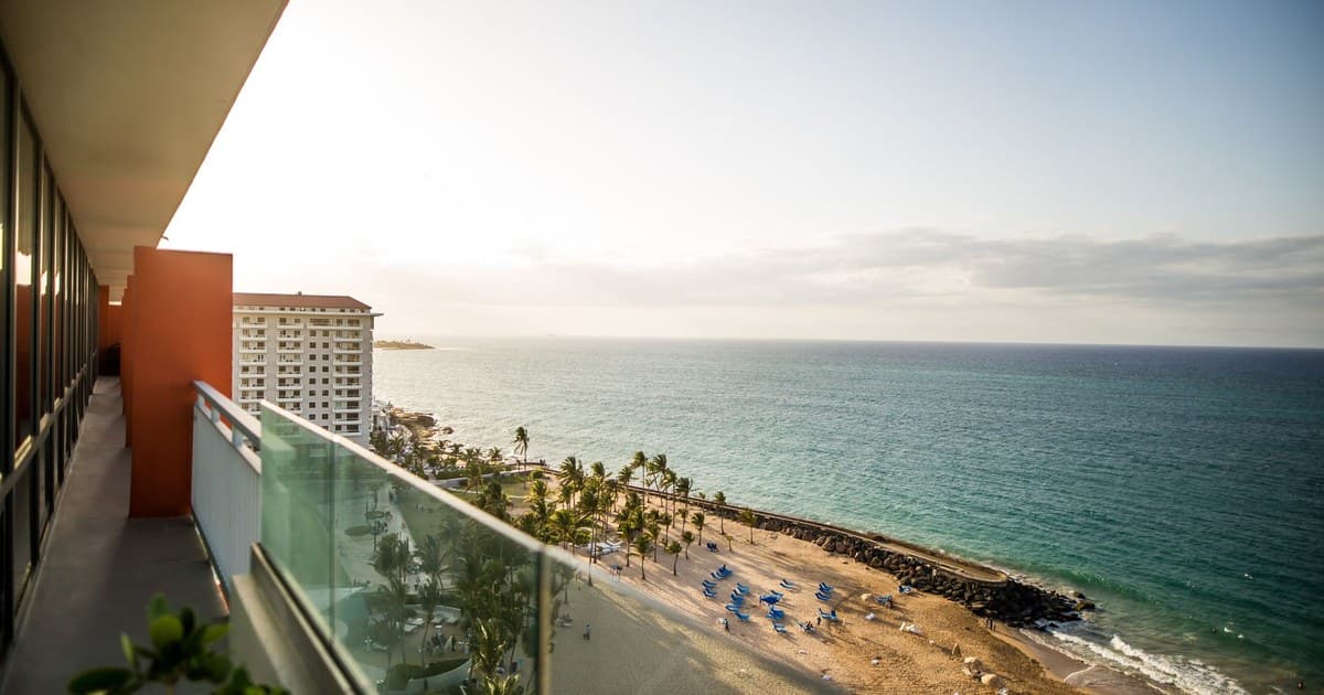 Breathtaking view of a tropical beach from a resort terrace overlooking the ocean during daytime.