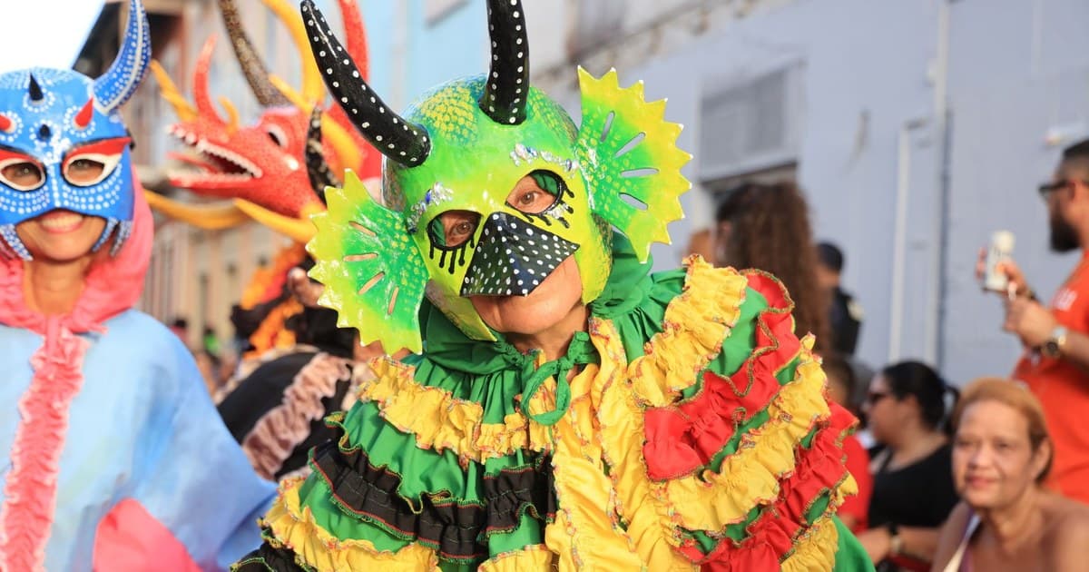 Colorful costumes and masks at a lively carnival parade outdoors.